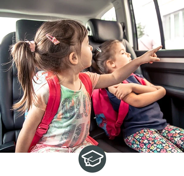 Kinder im Auto mit Schulrucksäcken fahren zur Schule